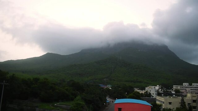 Beautiful view of Girnar mountain with green trees and top of mountain covered with clouds during monsoon season. At Junagadh, Gujarat, India