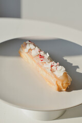 French eclair on white plate 
