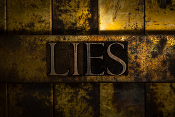 Lies text on vintage textured silver grunge copper and gold background