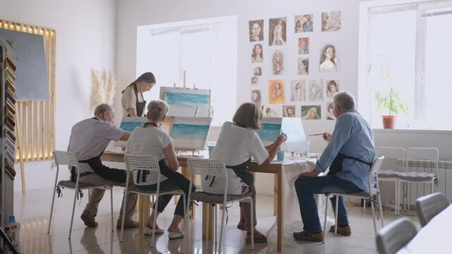 Like senior friends attending together at a painting class. small group taking a variety of fun classes together. A group of elderly people attend a master class on drawing together spending time.