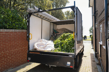 Cut green hedging and green waste in the back of an open truck waiting to be removed from a home. - 448284813