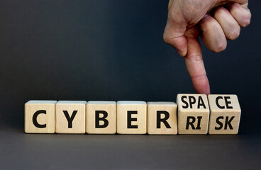 Cyber-space vs cyber-risk symbol. Businessman turns wooden cubes, changes words Cyber-risk to cyber-space. Beautiful grey background. Cyber-space vs cyber-risk concept. Copy space.