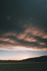Schöne Wolken nach Regen mit Feld bei Sonnenuntergang
