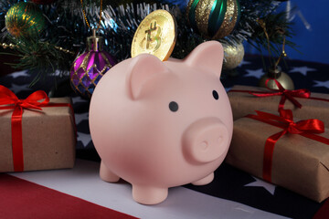 opening piggy bank pig with golden bitcoin under the christmas tree next to christmas gifts on the usa flag, close-up