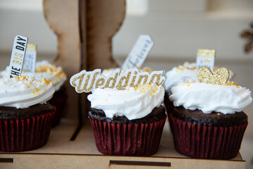 Chocolate cupcake with white icing and wedding topper