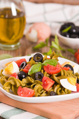 Fusilli pasta with cherry tomatoes, eggs and black olives.