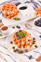 Waffles with blueberries and whipped cream.