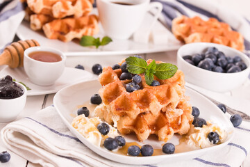 Waffles with blueberries and whipped cream.