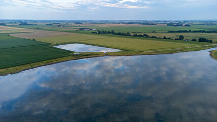 Fototapeta na wymiar Luftaufnahme von einem blauen See und weiter grüner Landschaft