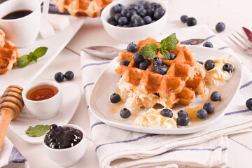 Waffles with blueberries and whipped cream.