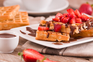 Waffles with strawberries and chocolate cream.