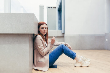 young frustrated depressed woman sitting on the street lost her job or has financial problems...