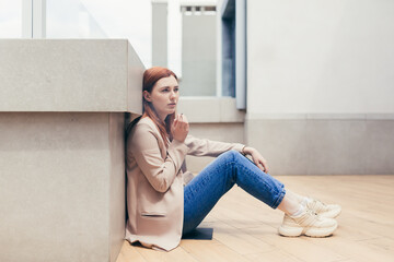 young frustrated depressed woman sitting on the street lost her job or has financial problems smoking a cigarette. lonely female student girl has stress at work. unemployed Lady with grief outdoors