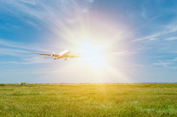 Passenger plane over a green field. Dawn in the morning outdoors. Transport and travel