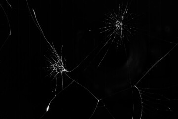 Broken glass of a smartphone with cracks on a black background for concept, collage, mockup. Close-up of cracks in the glass as white on black
