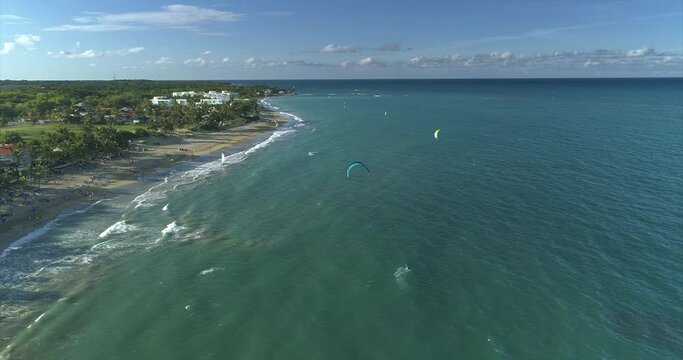 Many kiters ride at sunset from the lagoon near the small resort town. Water sports. Drone view of the blue daguna in the sunset light.