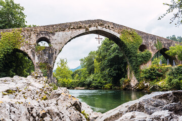 Fototapeta na wymiar Roman bridge of medieval origin over the Sella river in the city of Cangas de Onis, Asturias, Spain.