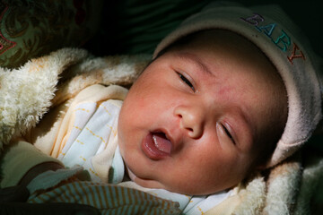 Newborn baby yawning for the first time in sunlight.