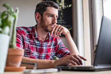 Man using laptop on desk working from home