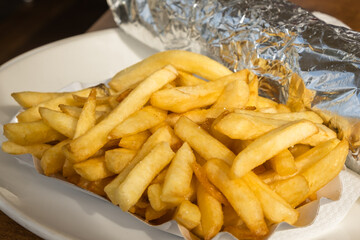 Kebab and French fries recipe on a white dish table in an European country.