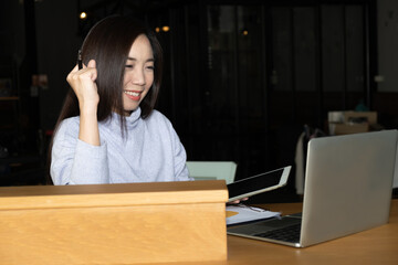 Smart beautiful clever Asian female thinking of serious information of summary positive study and business script essay in front of computer laptop at modern office table with the comfort atmosphere