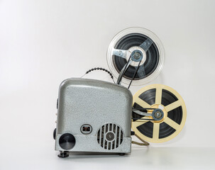Old vintage film projector for watching films on film strip on a white background.