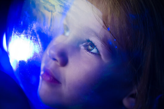 girl dreams of becoming astronaut and flying into space. reflection of planet