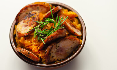 Traditional Polish dish called bigos made of sauerkraut, sausage and mushrooms, food served warm in a ceramic bowl