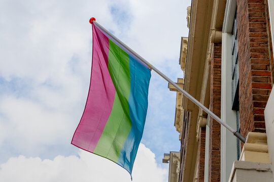 Celebrate of 20th years same-sex marriages in Holland, Polysexual flag hanging outside building, The flag has three stripes, pink, green and blue, The symbol of LGBTQ, Amsterdam, Netherlands.