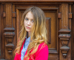 A blonde teenage girl is thoughtfully  looking at you..