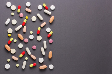 a lot of pills, vitamins, capsules on a grey background