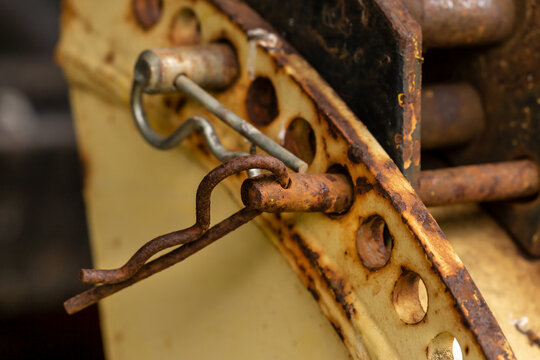 Close-up of rusty sping cotter pins on a frontloader vehicle