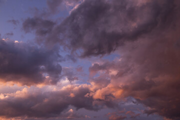 Obraz na płótnie Canvas Epic sunset storm sky. Dark grey pink purple orange violet thunderstorm clouds in sunlight abstract background texture