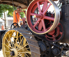 Salem, Oregon - 7-27-2021: The iron spoked rear wheels and fly wheel of a vintage steam powered...