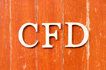 Alphabet letter in word CFD (Abbreviation of Contract for Difference) on old red color wood plate background