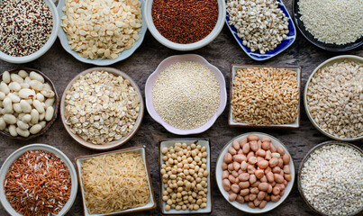 Variety kinds of white, brown, and dark brown natural organic  cereal and grain seeds in ceramic bowl on grunge background in dark tone, for healthy or clean food or agricultural product concept