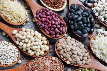 Closed up dry organic soybean seeds in wodoen spoon with lentils, red and black bean, mung bean,...