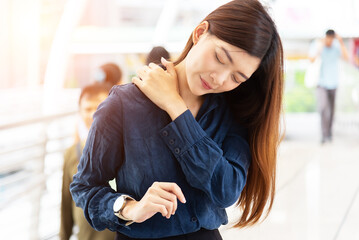 Obraz premium An Asian business woman Portrait of young stressed woman touching aching back with pained expression, suffering from backache after working