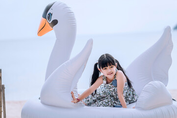 Happy smiling girl lying on fancy swimming ring, summer vacation and relax concept