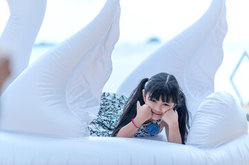 Happy smiling girl lying on fancy swimming ring, summer vacation and relax concept