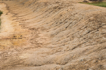 Arid landscape and Eroded soil concept. Background image of a dried cracked clay with traces from a erosion .Natural picture taken during the dry season.