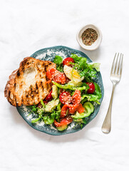 Delicious breakfast, snack - salad with salmon, egg, vegetables, lettuce and grilled bread on a light background, top view