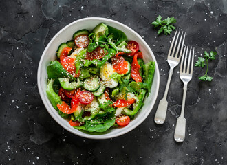 Delicious breakfast, snack, tapas - salad with salted salmon, egg, vegetables, lettuce on a dark background, top view