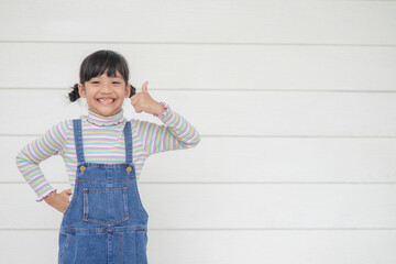 Portrait of little cute Asian girl with her thump up, advertisement concept, little Asian teenage thumps up with the white background and space