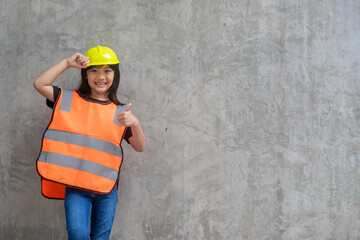 Obraz na płótnie Canvas Asian Kid girl wearing reflective shirts and a hat yellow. To learning and enhance development, little architect.