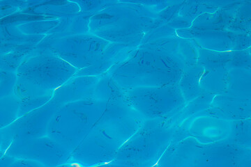 Obraz premium Beautiful blue ripple water surface in swimming pool with sun reflection