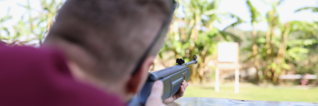 Man shoots a weapon at target in street shooting range