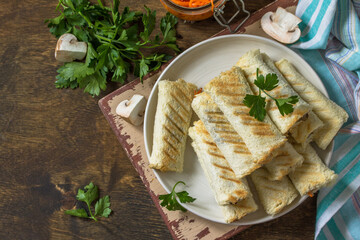 Fast breakfast. Bread toast roll sandwich with mushrooms and carrots spices on a rustic table. Top view flat lay background. Copy space.