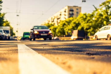 Sunny day in a city, view of the approaching cars to the road level