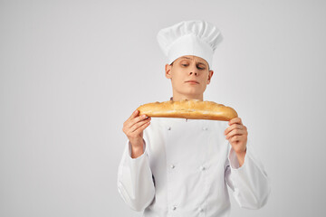 a man in a chef's uniform Holding a loaf bakery professional work